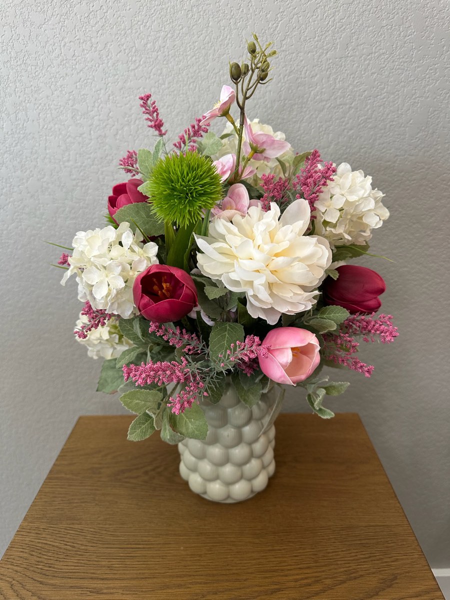 Faux arrangement of pink tulips, white peonies and hydrangea in a white hobnail vase