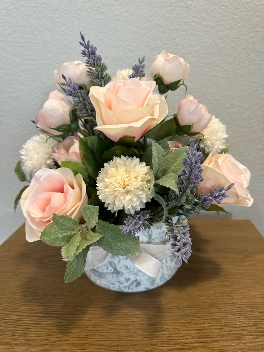 Faux blush-pink roses with lavender sprigs in a blue toile pot