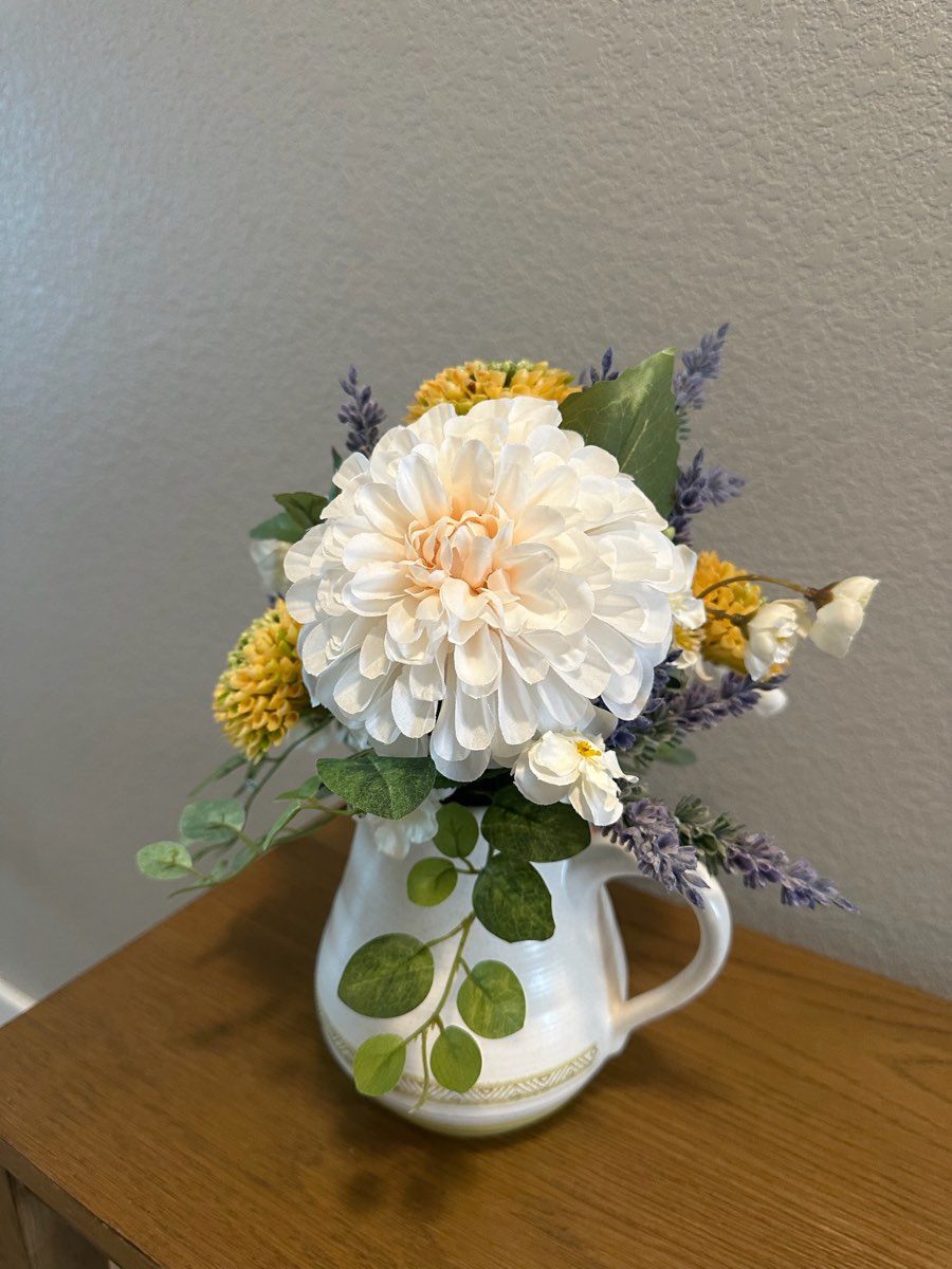 Faux cream pom-pom dahlia with lavender in a white ceramic pitcher